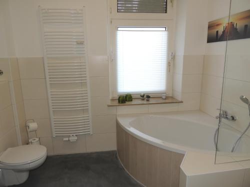 a bathroom with a tub and a toilet and a sink at Zentrales Apartment in Gelsenkirchen in Gelsenkirchen