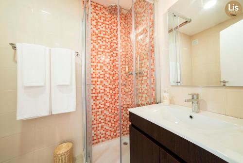 La salle de bains est pourvue d'un lavabo et d'une douche. dans l'établissement Lis Apartments, à Lisbonne
