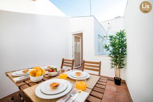 a dining room table with plates of food and orange juice at Lis Apartments in Lisbon