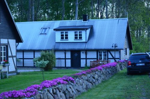 a house with a gray roof and a stone wall at Smedsgården in Höganäs