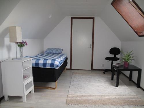a bedroom with a bed and a desk and a table at Smedsgården in Höganäs