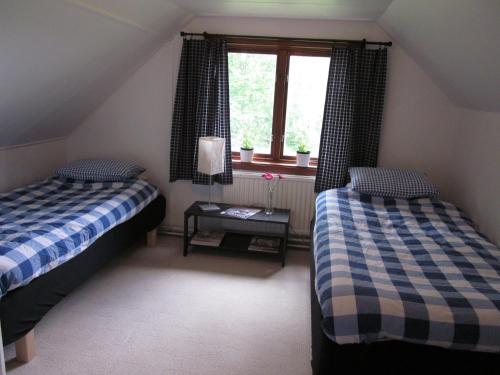 um quarto no sótão com 2 camas e uma janela em Smedsgården em Höganäs
