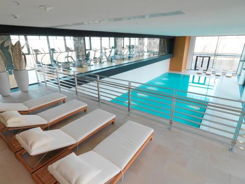 einen Pool mit Liegestühlen und einem Pool in der Unterkunft Lufthansa Seeheim - More than a Conference Hotel in Seeheim-Jugenheim