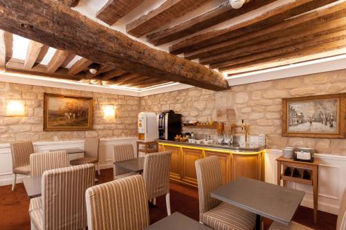 un restaurant avec des tables et des chaises et une cuisine dans l'établissement Hotel Bonaparte, à Paris