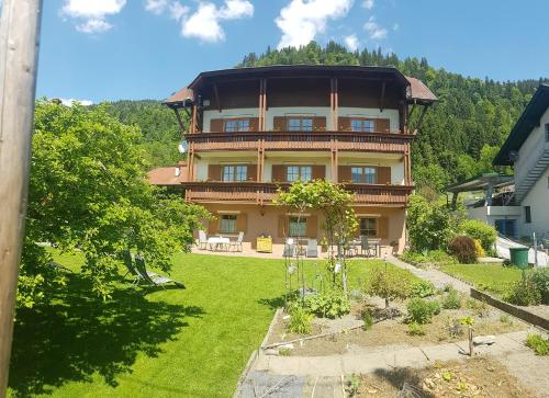 a large house with a garden in front of it at Gästehaus Struggl in Steindorf am Ossiacher See