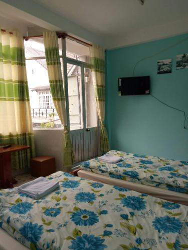 a bedroom with two beds and a window at Bình An in Da Lat