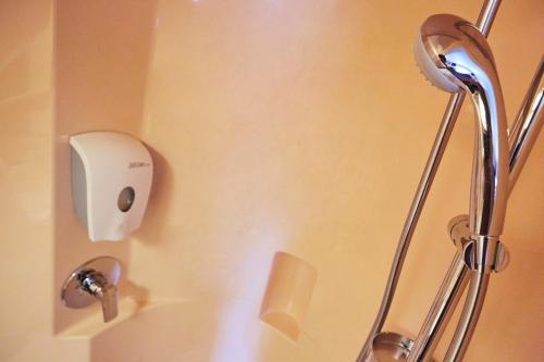 a shower head on a wall in a bathroom at Premiere Classe Roissy CDG - Paris Nord 2 - Parc des Expositions in Roissy-en-France