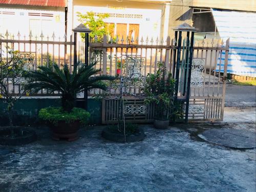 a wooden gate with plants in front of a house at Bảo Lộc Homestay in Bao Loc