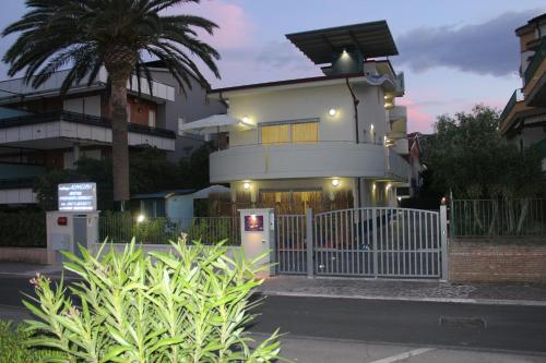 a house with a white fence in front of a building at Residenza Alpaluba in Vasto