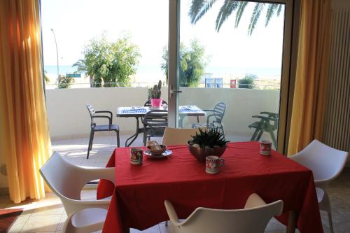 a red table with white chairs and a red table cloth at Residenza Alpaluba in Vasto