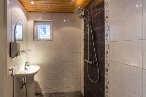 a bathroom with a shower and a sink at Villa Mustikkakumpu in Sonka