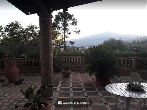 d'une terrasse avec une table et une clôture en pierre. dans l'établissement Villa Chiarenza Maison d'Hotes, à Giardini Naxos