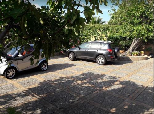 two cars are parked in a parking lot at Villa Chiarenza Maison d'Hotes in Giardini Naxos