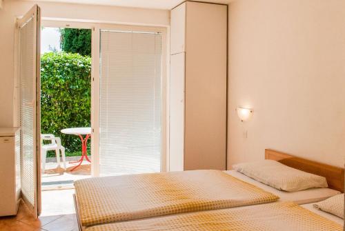 a bedroom with two beds and a door to a patio at Apartment Ohrid Forever in Lagadin