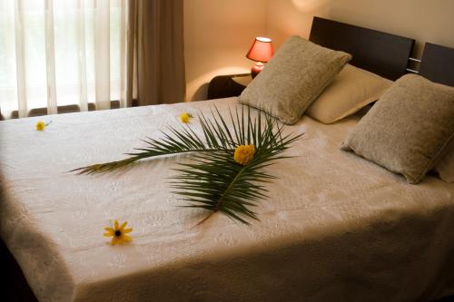 Un dormitorio con una cama blanca con flores. en SB Rentals Apartments in Royal Dreams Complex, en Sunny Beach