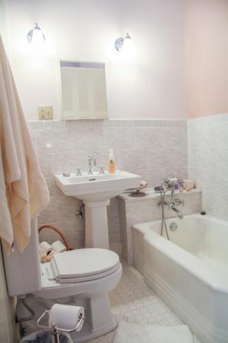 a bathroom with a toilet and a sink and a tub at Riverboat Bed & Breakfast in Natchez