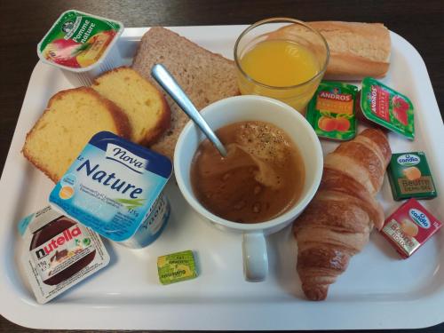 a plate of food with bread and a cup of coffee at Premiere Classe Roissy CDG - Paris Nord 2 - Parc des Expositions in Roissy-en-France