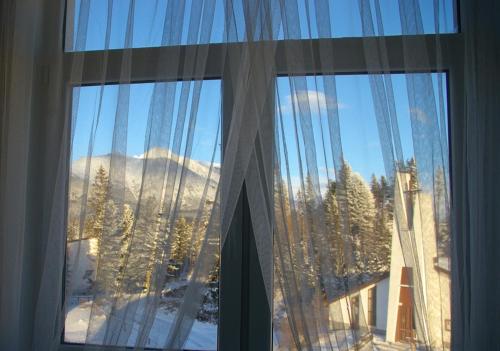 a window with a view of a snowy mountain at Vila Polar in Štrbské Pleso
