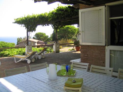 une table avec un tissu de table blanc sur une terrasse dans l'établissement La Bouganville, à Giglio Porto