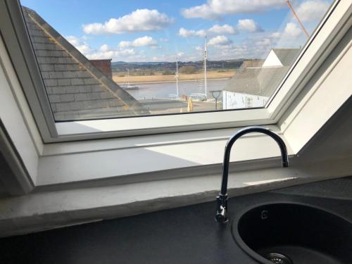 a window with a sink and a view of an airport at Route 2 Apartments in Topsham