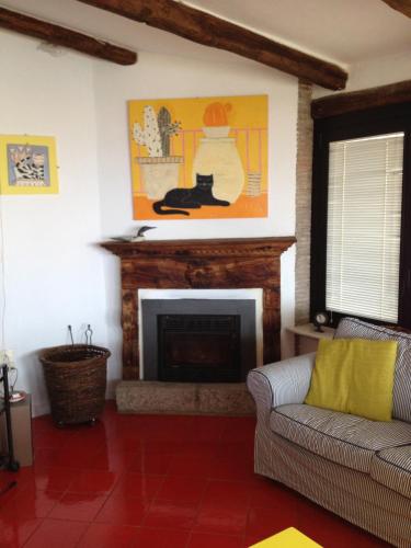 a living room with a fireplace with a cat on the wall at La Bouganville in Giglio Porto