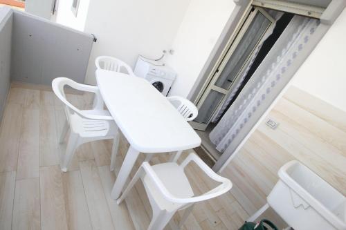 - une table blanche et 2 chaises blanches dans une pièce dans l'établissement Vista Mare Rivabella, à Gallipoli