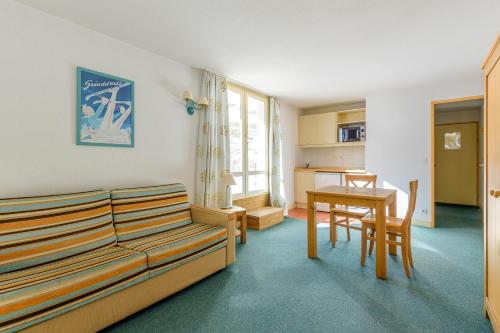 un salon avec un canapé et une table dans l'établissement Residence Le Montana - maeva Home, à La Mongie