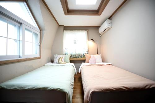deux lits dans une petite pièce avec une fenêtre dans l'établissement The One Hostel Hongdae in Seoul - Foreigner Only, à Séoul