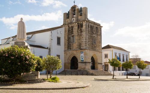 an old church with a tower on top of it at 1977 in Faro
