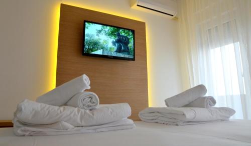 a hotel room with towels on a bed with a television at Lux Apartmani in Kladovo