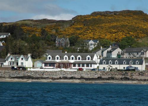 a group of houses on the shore of the water at Myrtle Bank Hotel in Gairloch