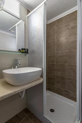 a bathroom with a sink and a shower at Milos Apartments in Adamantas