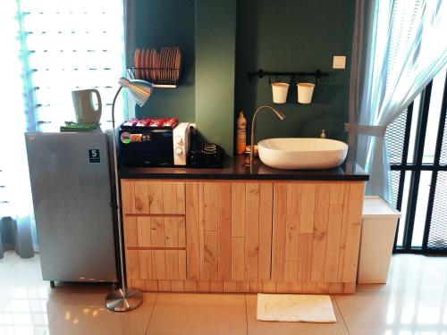 eine Küche mit einer Theke mit einer Spüle und einem Kühlschrank in der Unterkunft Le Bleu Malacca in Malakka