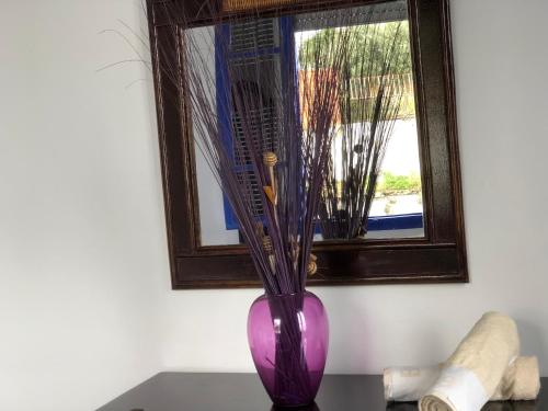a purple vase sitting on a table next to a window at El Muniria in Tangier