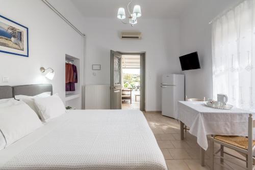 - une chambre blanche avec un lit blanc et une table dans l'établissement Milos Apartments, à Adamas