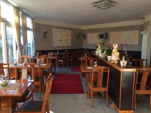 a restaurant with wooden tables and chairs and a bar at Hotel Restaurant Artemis in Weisenheim am Berg