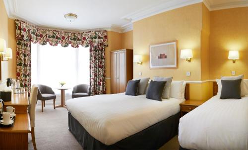 a hotel room with two beds and a window at Riviera Town House in Scarborough