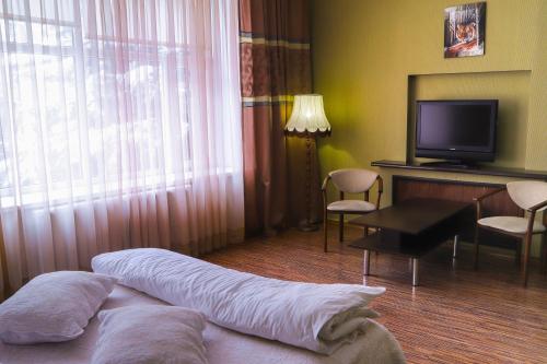 a hotel room with a bed and a television at Safari-Club in Vinnytsya
