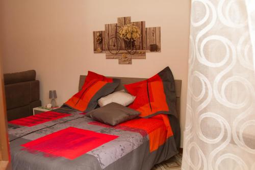 a bedroom with a bed with red and orange pillows at Il Borgo in Agerola