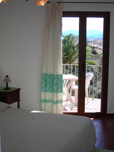 a bedroom with a bed and a view of a balcony at Bed & Breakfast Dessole in Olbia