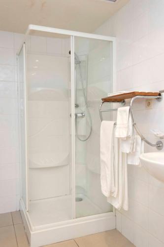 a shower with a glass door in a bathroom at Hotel De Croone in Ninove