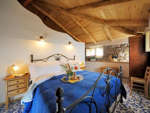 a bedroom with a blue bed and a wooden ceiling at Residenza Matarazzo e Le Sue Soffitte in Castellabate