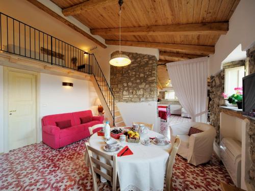 sala de estar con mesa y sofá rojo en Residenza Matarazzo e Le Sue Soffitte en Castellabate