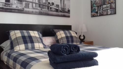 a bedroom with a bed with blue towels on it at Neptuno Rooms in Arrecife