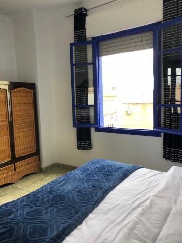 a bedroom with a bed and a window at El Muniria in Tangier