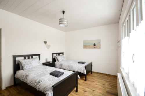 Habitación con 2 camas, paredes blancas y suelo de madera. en Interlaken Central 2, en Interlaken