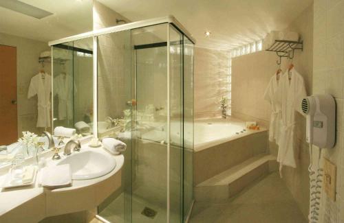 ロサリオにあるPlaza Real Suites Hotelのシャワー、洗面台、浴槽を備えたバスルーム