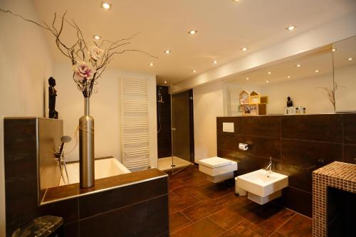 a bathroom with a vase with flowers in it at Villa Dragona Dufti-Kuss Gästehaus im Herzen von Rees in Rees