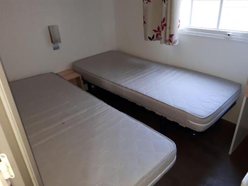 a small room with two beds and a window at Mobil Home Sainte Baume in Nans-les-Pins