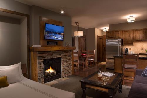 a living room with a fireplace with a tv on top at Teton Mountain Lodge and Spa, a Noble House Resort in Teton Village